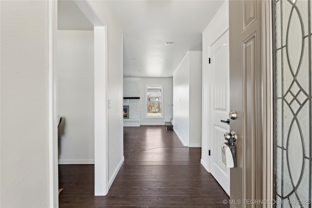 hallway with baseboards and dark wood-type flooring