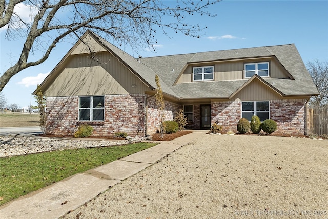 view of front of house featuring a shingled roof and brick siding