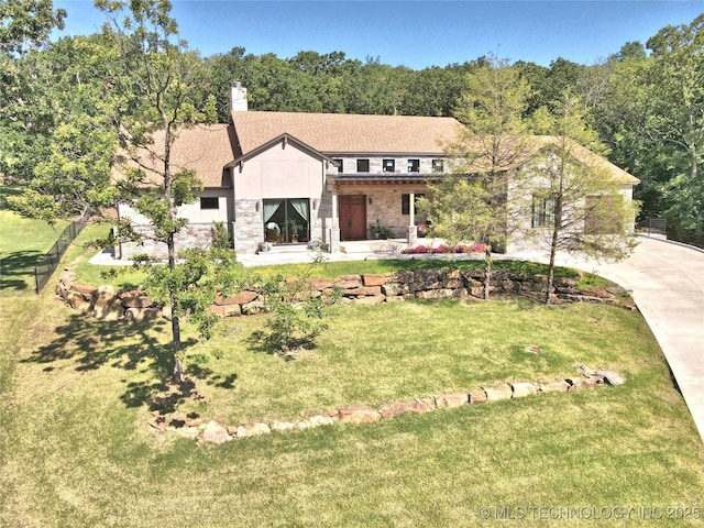 8890 S 39th W Ave, Tulsa, OK 74132 - view of front of home with stone siding, a front yard, and a chimney