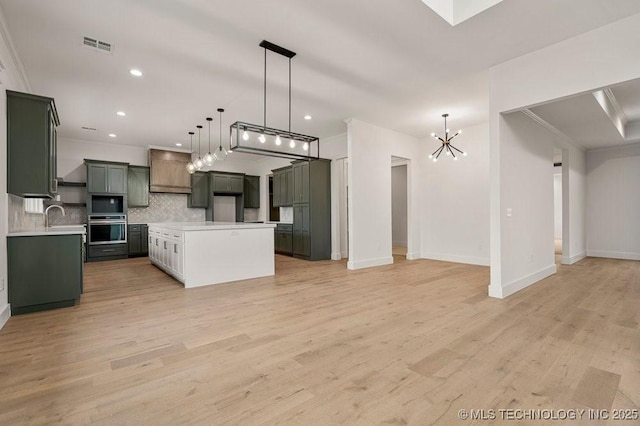 kitchen with ornamental molding, open floor plan, a sink, and decorative backsplash