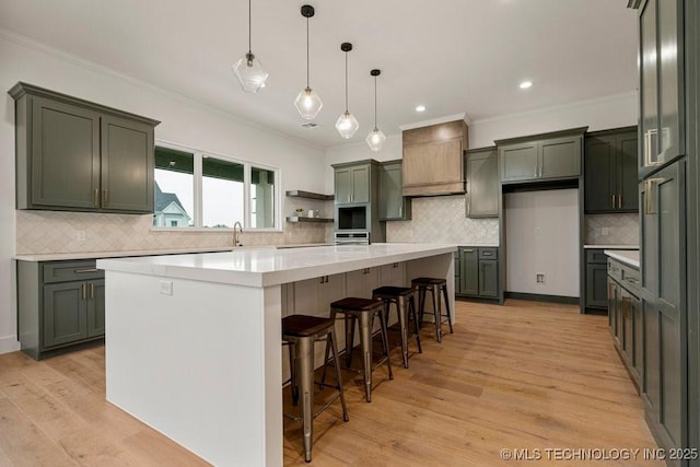 kitchen featuring light wood-style flooring, ornamental molding, and a center island