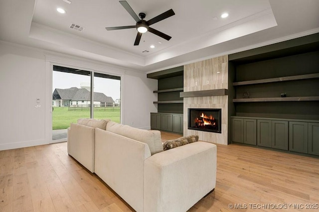 living room featuring a raised ceiling and light wood finished floors