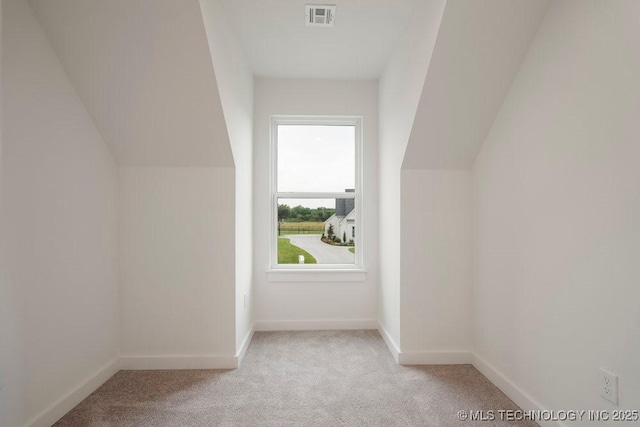 bonus room featuring baseboards, vaulted ceiling, visible vents, and light colored carpet