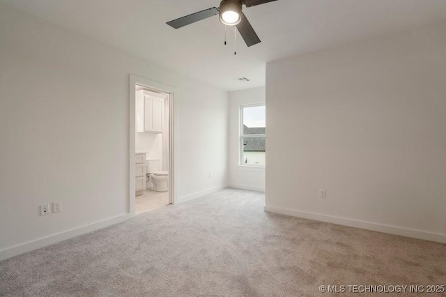 unfurnished bedroom featuring light colored carpet, visible vents, a ceiling fan, connected bathroom, and baseboards