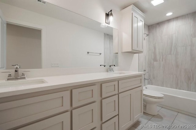 bathroom featuring double vanity, a sink, toilet, and tile patterned floors