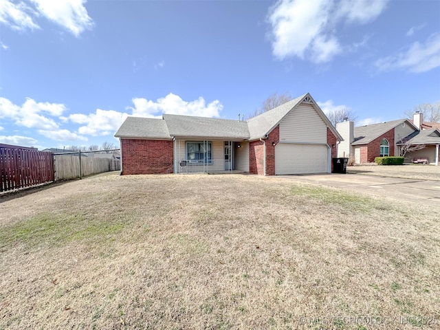 ranch-style house featuring brick siding, an attached garage, fence, and a front yard