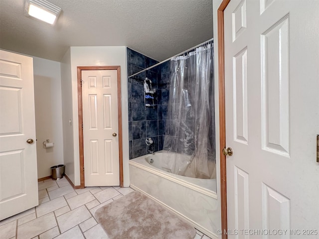 full bath featuring a textured ceiling, shower / tub combo, and baseboards