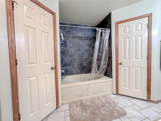 full bath with a textured ceiling, shower / bath combo, and tile patterned flooring