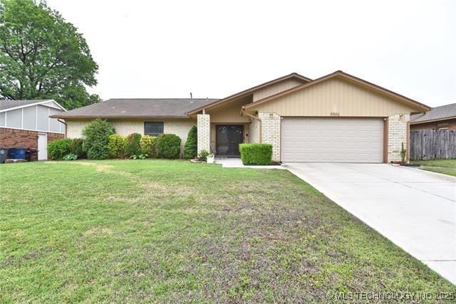 single story home with brick siding, a front yard, fence, a garage, and driveway