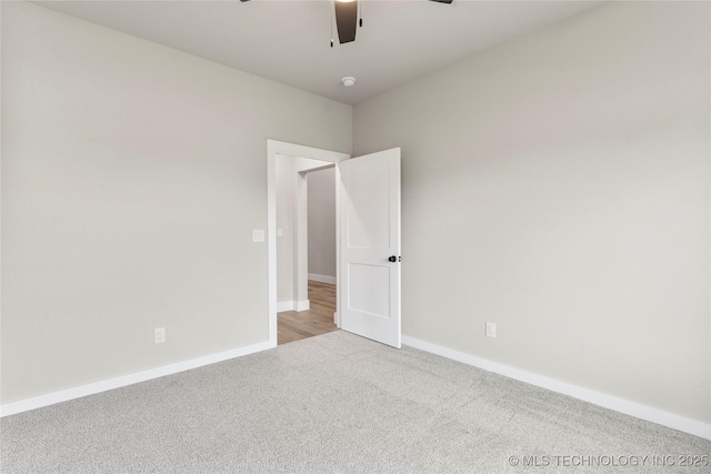 unfurnished room with carpet flooring, a ceiling fan, and baseboards