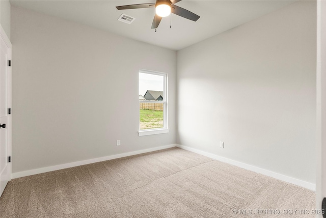 unfurnished room with baseboards, a ceiling fan, visible vents, and carpet
