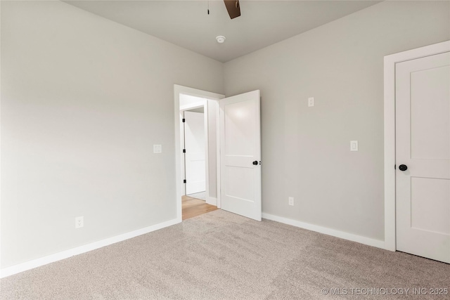 unfurnished bedroom featuring light carpet, a ceiling fan, and baseboards