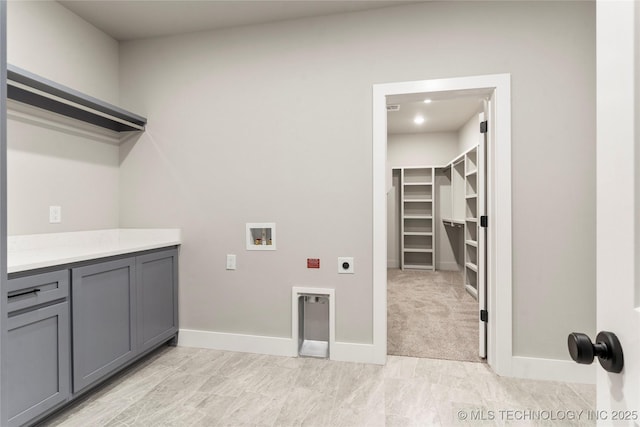 washroom with hookup for an electric dryer, cabinet space, hookup for a washing machine, and baseboards