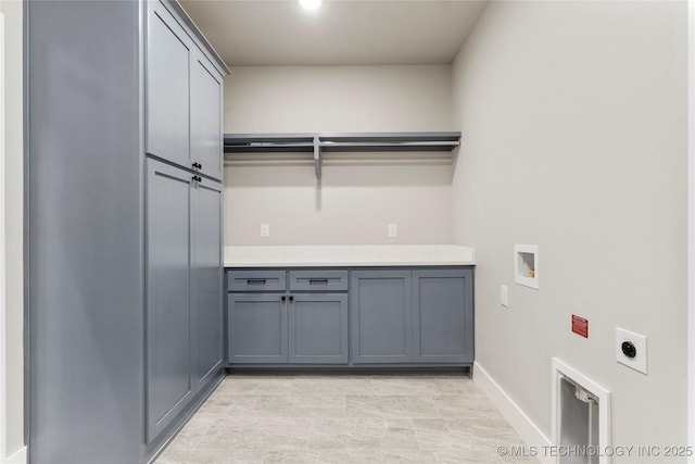 washroom with cabinet space, hookup for a washing machine, baseboards, and electric dryer hookup