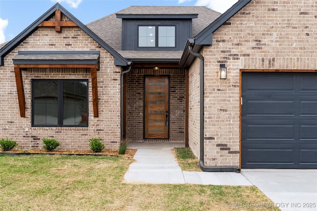 doorway to property with a garage, brick siding, a shingled roof, and a lawn