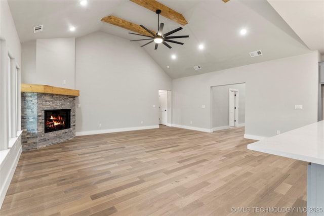 unfurnished living room with high vaulted ceiling, a ceiling fan, a stone fireplace, baseboards, and visible vents