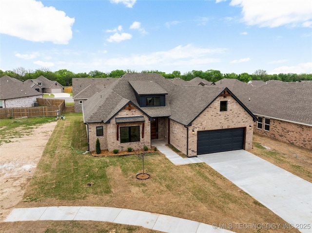 view of front of property featuring fence, roof with shingles, concrete driveway, brick siding, and a front yard