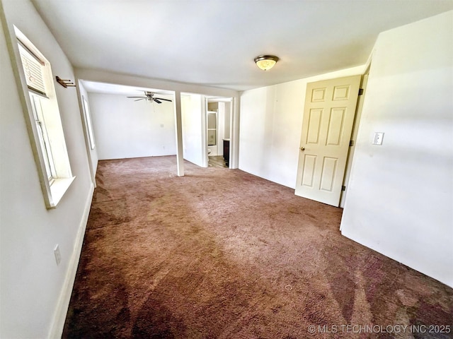 carpeted empty room with a ceiling fan