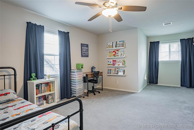 carpeted bedroom featuring a ceiling fan, visible vents, and baseboards