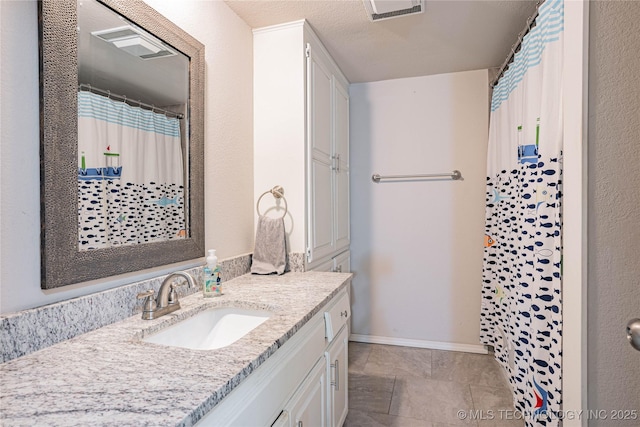 full bath featuring a shower with shower curtain, visible vents, vanity, and baseboards