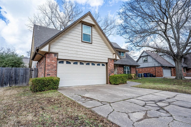 traditional home with roof with shingles, fence, concrete driveway, and brick siding