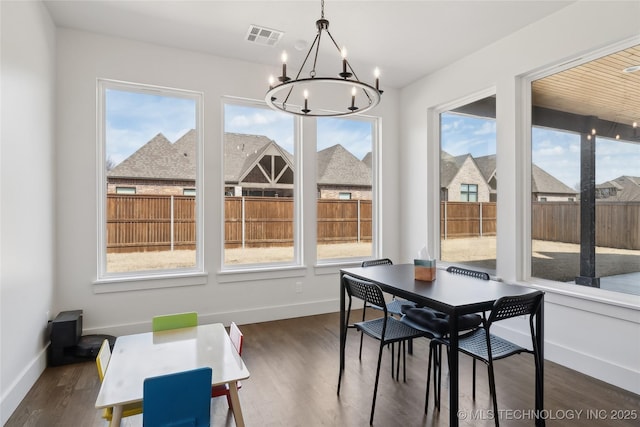 dining space featuring dark wood-type flooring, visible vents, and a healthy amount of sunlight