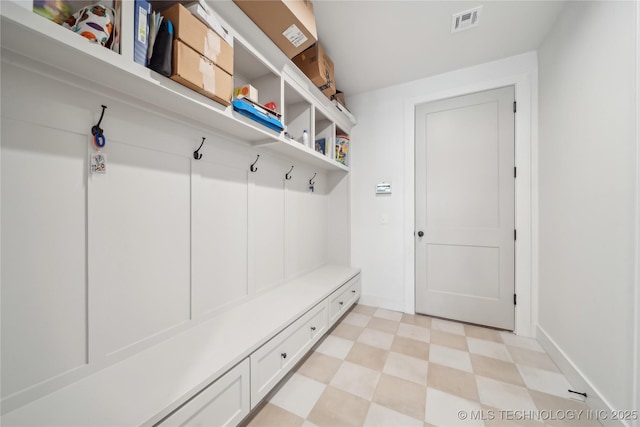 mudroom featuring light floors, visible vents, and baseboards