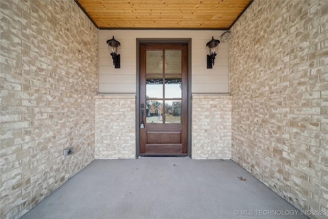 doorway to property with brick siding