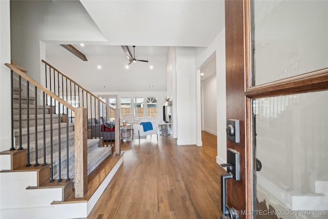 foyer entrance with ceiling fan, wood finished floors, baseboards, stairs, and beam ceiling