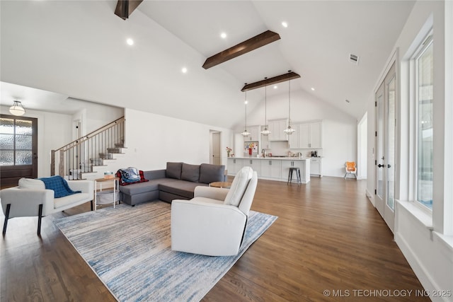 living room featuring visible vents, stairway, dark wood finished floors, and beam ceiling