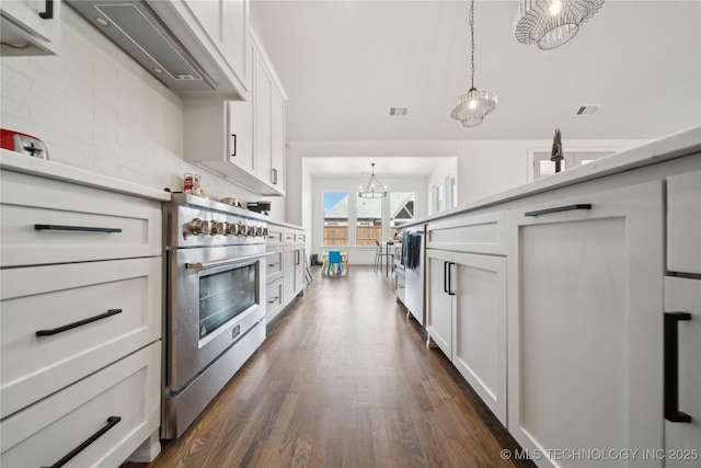 kitchen featuring a notable chandelier, white cabinets, light countertops, high end stainless steel range oven, and dark wood-style floors