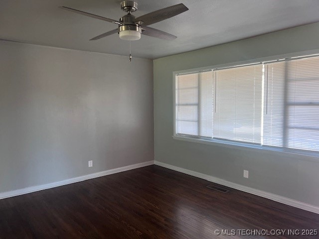 empty room with visible vents, baseboards, ceiling fan, and wood finished floors