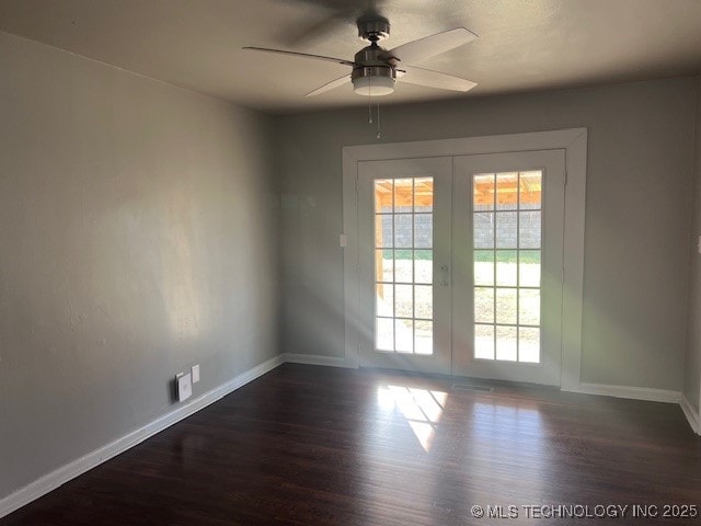 spare room featuring dark wood-style floors, ceiling fan, french doors, and baseboards