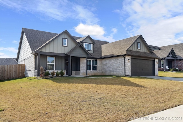 view of front of home with a garage, a shingled roof, fence, a front lawn, and brick siding