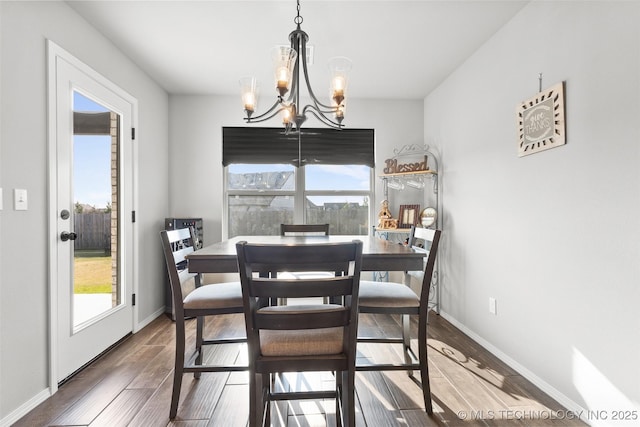 dining area with a chandelier, wood finished floors, and baseboards