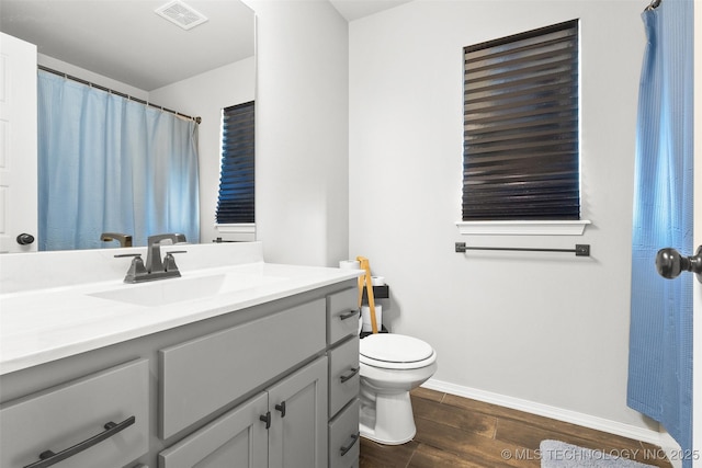 bathroom with visible vents, baseboards, toilet, wood tiled floor, and vanity