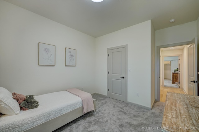 bedroom with baseboards and light colored carpet