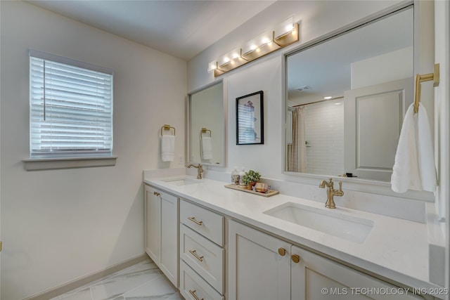 full bath featuring marble finish floor, double vanity, a sink, and a shower with curtain