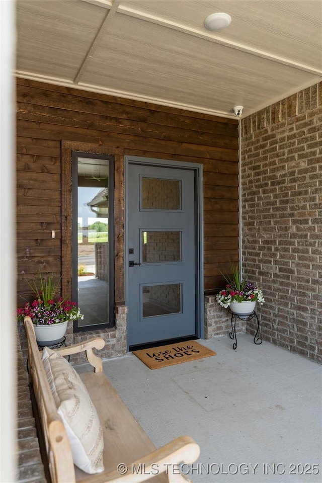 entrance to property featuring brick siding