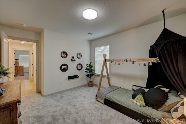 carpeted bedroom with visible vents and baseboards