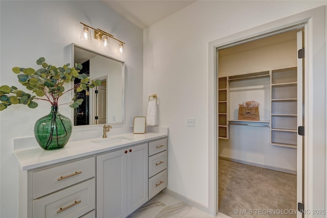 bathroom with marble finish floor, vanity, and baseboards