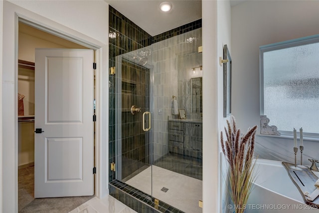 full bath featuring a spacious closet, a stall shower, and a bathing tub