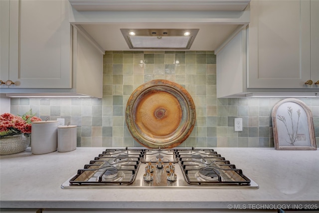 interior details featuring stainless steel gas stovetop, light countertops, and backsplash