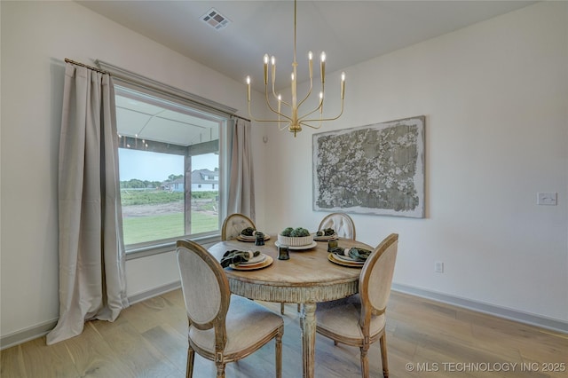 dining room with light wood-style floors, a chandelier, visible vents, and baseboards