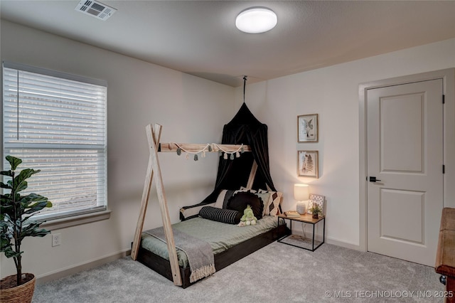 carpeted bedroom featuring multiple windows, visible vents, and baseboards