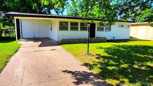 exterior space featuring driveway, a carport, and a front yard