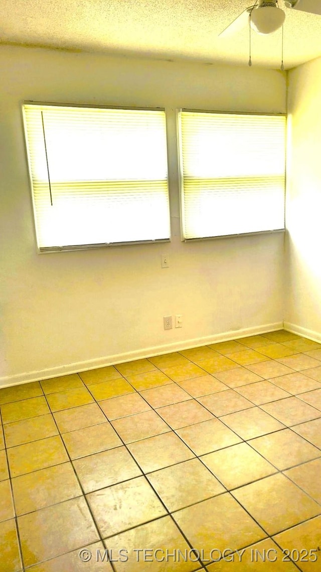 unfurnished room with a wealth of natural light, light tile patterned flooring, and a textured ceiling