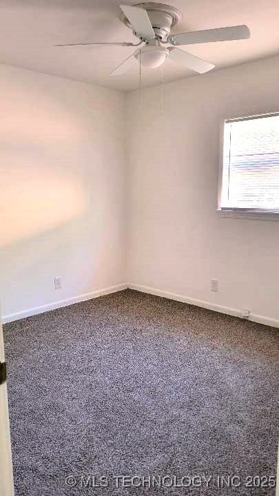 carpeted empty room featuring a ceiling fan and baseboards