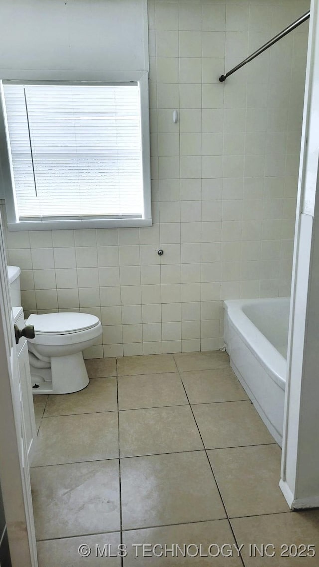 bathroom with tile walls, toilet, and tile patterned floors