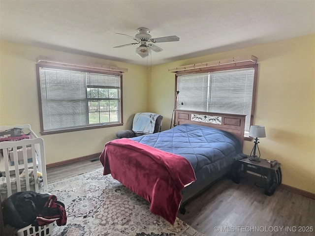 bedroom featuring wood finished floors, a ceiling fan, and baseboards